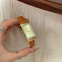 Brown with gold frame and gold face