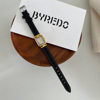 Black with gold frame and white face
