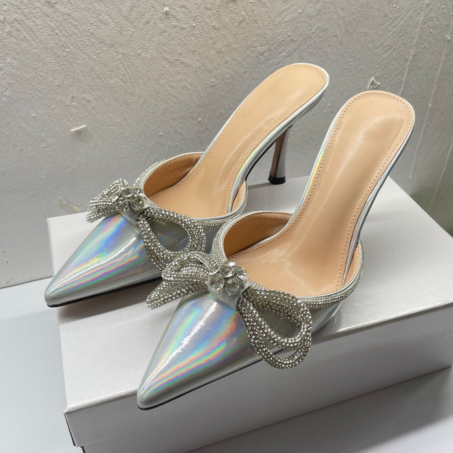 A kick of laser bow rhinestone high heel slippers, thin heels, pointed toe and half flip-flops, wearing a new European and American style