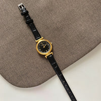 Black with gold frame and black face