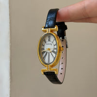 Black with gold frame and white face