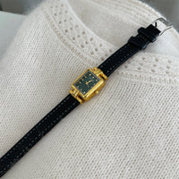Black belt with gold frame and green face
