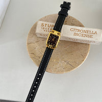 Black with gold frame and black face